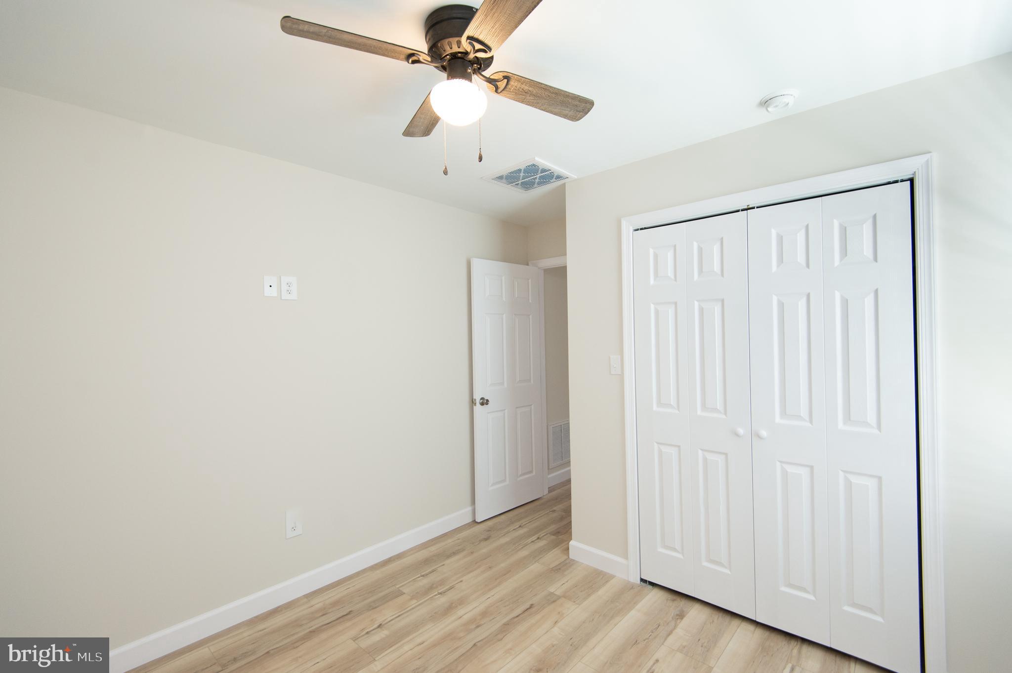 917 Springfield Avenue Cambridge, MD 21613 - Photo 26 of 42 an empty room with wooden floor fan and windows