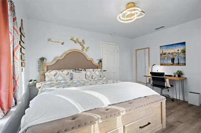 a bedroom with a bed and a lamp on dresser