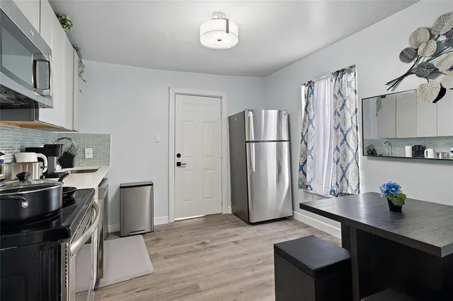 a kitchen with stainless steel appliances a refrigerator a sink a stove and cabinets