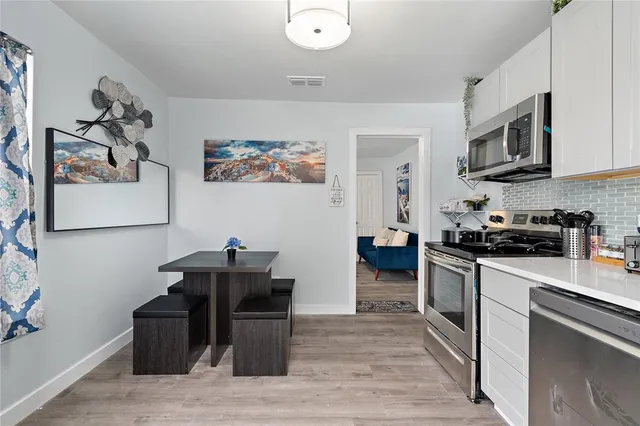 a kitchen with stainless steel appliances granite countertop a refrigerator and a stove top oven