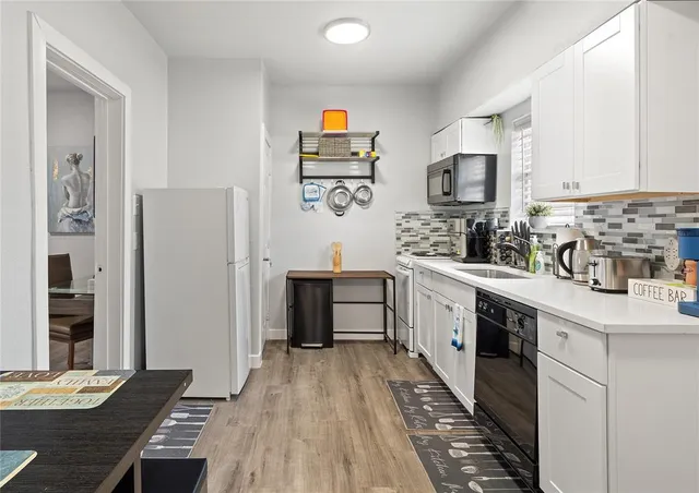 a kitchen with stainless steel appliances a stove top oven a sink a refrigerator and cabinets