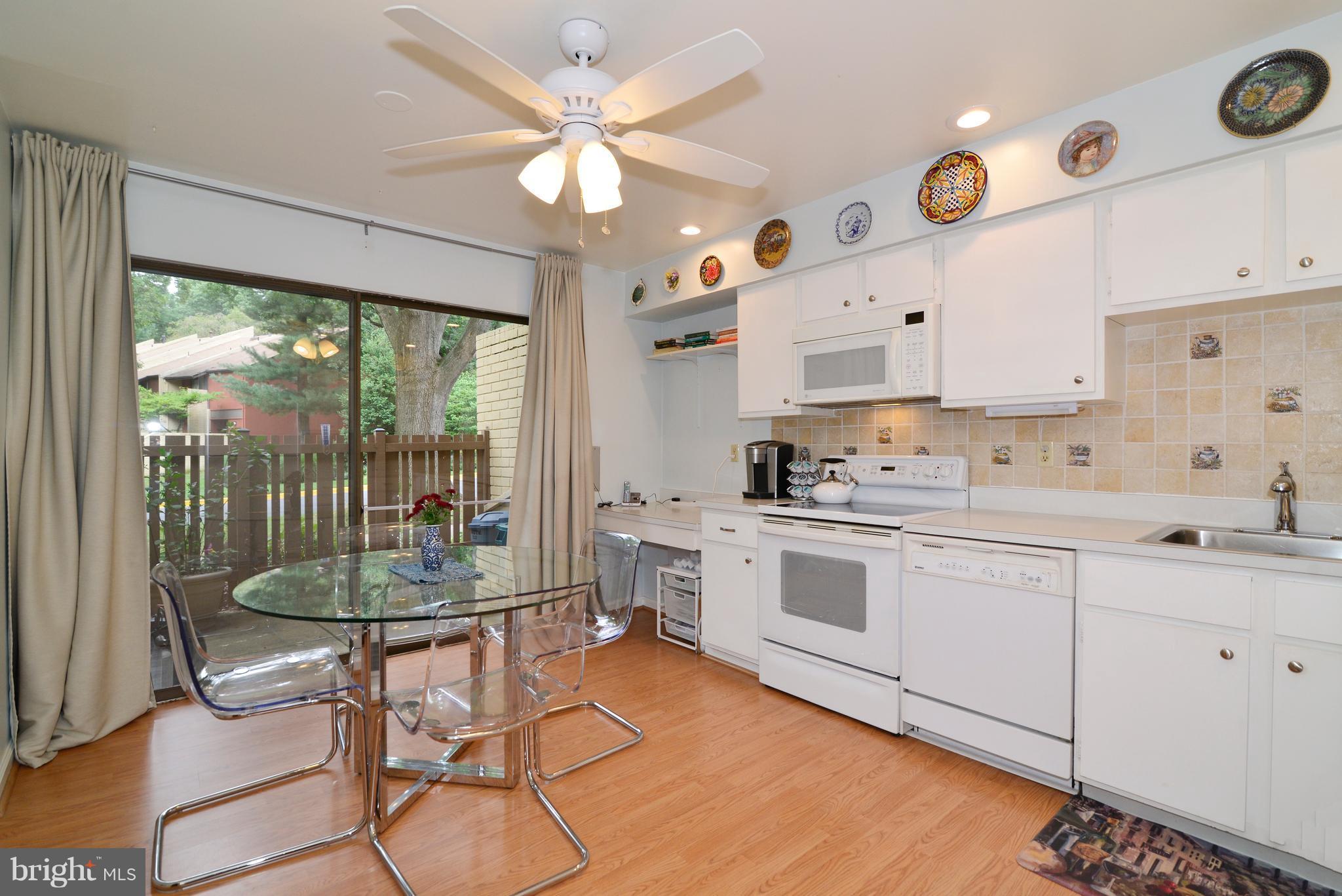 11161 Saffold Way Reston, VA 20190 - Photo 4 of 28 a kitchen with stainless steel appliances granite countertop a stove a sink dishwasher and white cabinets with wooden floor