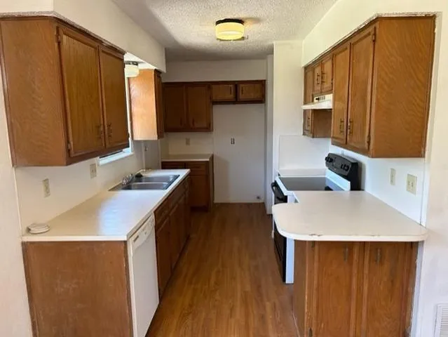 a kitchen with a sink a stove and cabinets