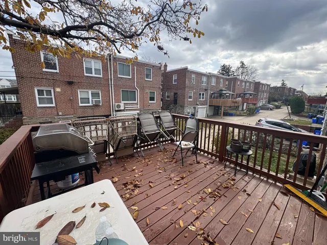 a view of a roof deck with table and chairs barbeque oven and a wooden floor