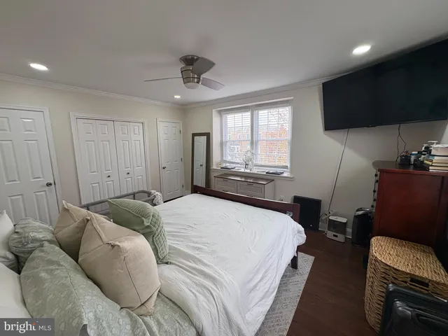 a bedroom with a bed tv and a window
