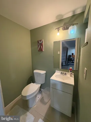 a bathroom with a toilet sink vanity and mirror