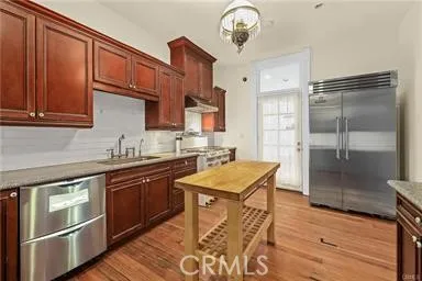 a kitchen with stainless steel appliances granite countertop a sink and wooden cabinets