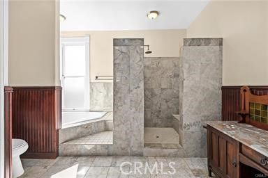 a bathroom with a granite countertop bathtub shower sink and toilet