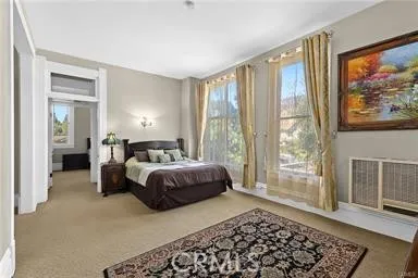 a bedroom with a bed lamp and a large window