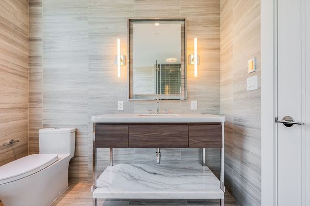 a bathroom with a toilet a sink and mirror