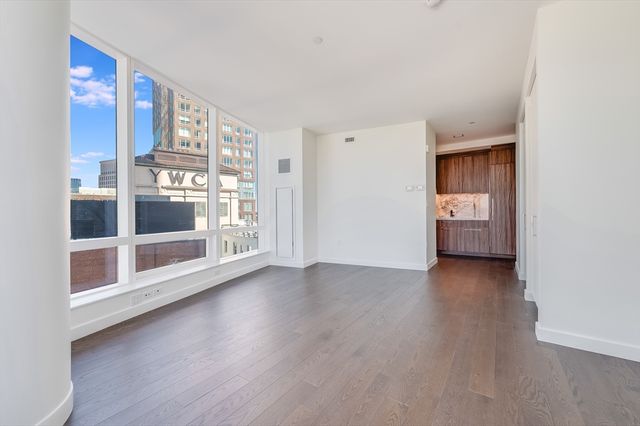 a view of a big room with wooden floor and windows