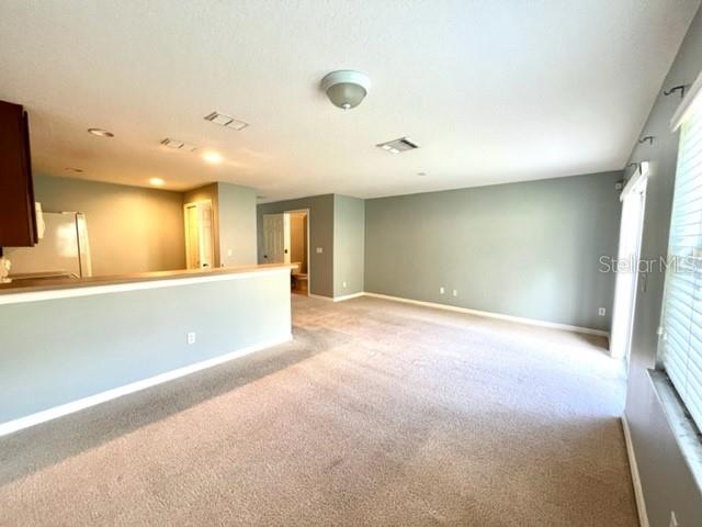 3896 Silverbell Loop Oviedo, FL 32765 - Photo 8 of 38 an empty room with a kitchen and windows