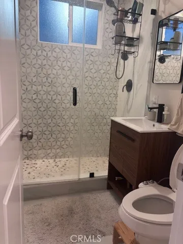 a bathroom with a sink a toilet and shower