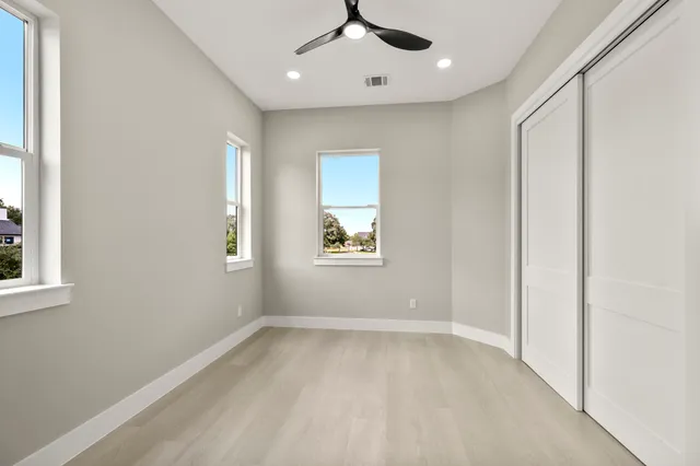 an empty room with windows and closet