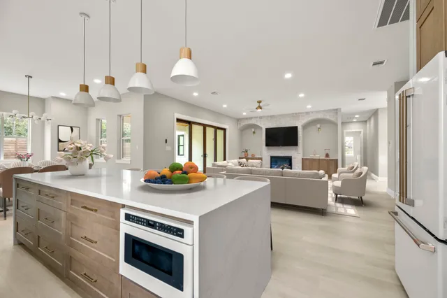 a open kitchen with a sink dishwasher a stove and a refrigerator with wooden floor