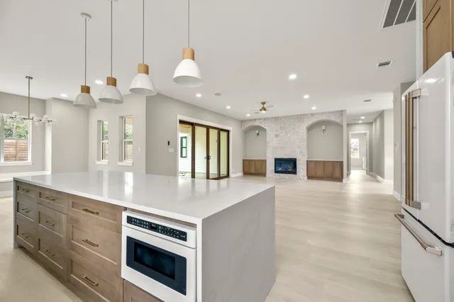 a living room with furniture kitchen area and a refrigerator