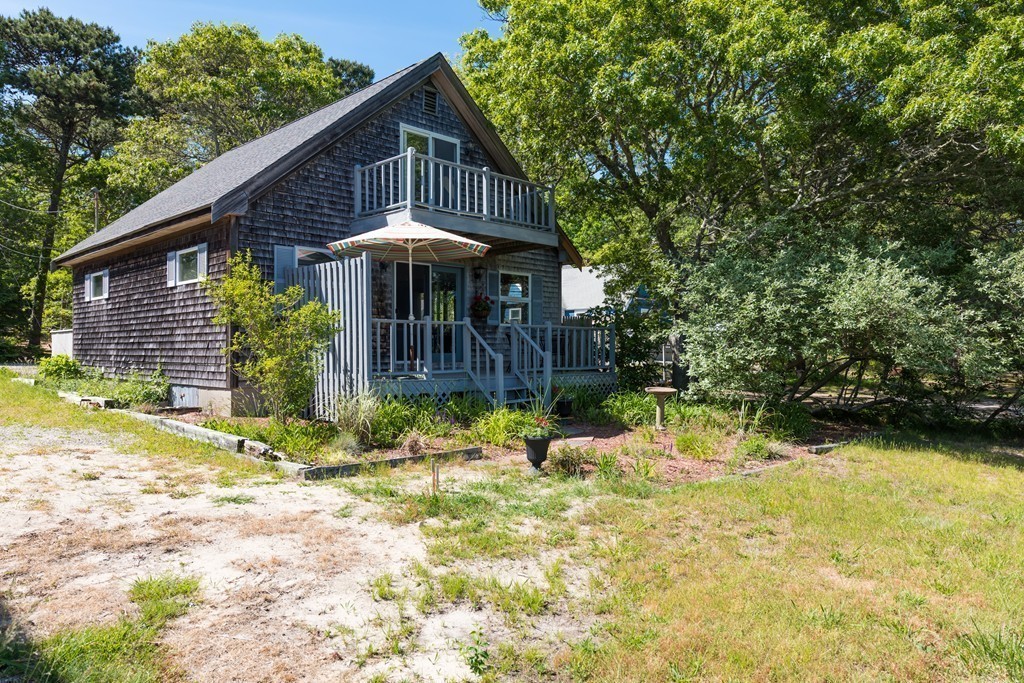 23 Riverside Road Mashpee, MA 02649 - Photo 8 of 19 a backyard of a house with yard and outdoor seating