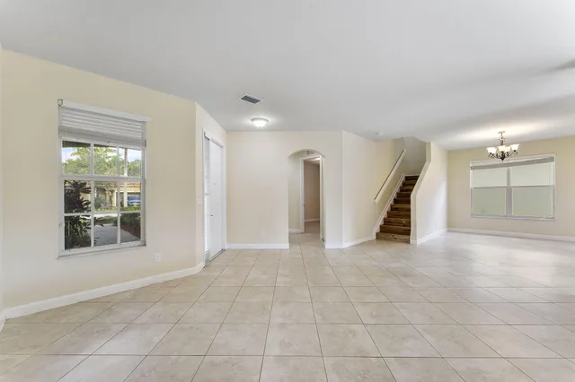 a view of an empty room with a window and cabinet