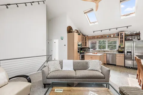 a living room with furniture and kitchen view