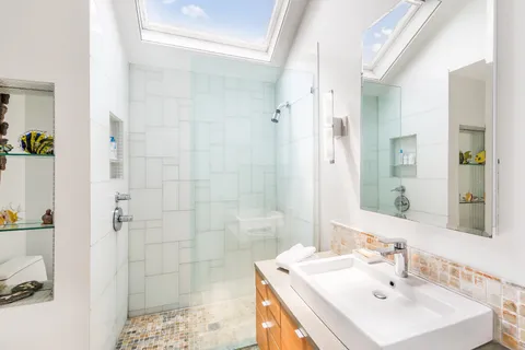 a bathroom with a sink a shower and a mirror