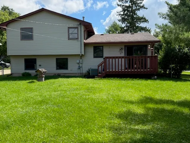 a view of a house with a yard plants and large tree