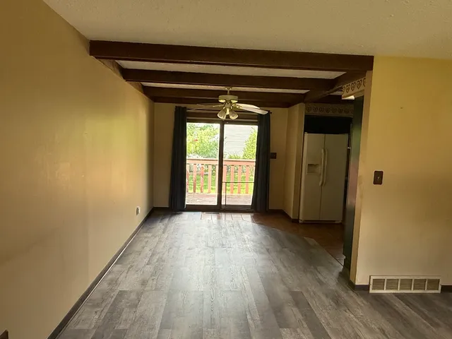 an empty room with wooden floor and a window