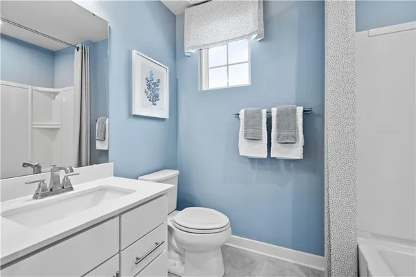 a bathroom with a toilet sink vanity and mirror