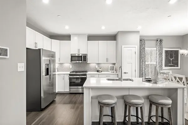 a kitchen with granite countertop a sink cabinets stainless steel appliances and dining table