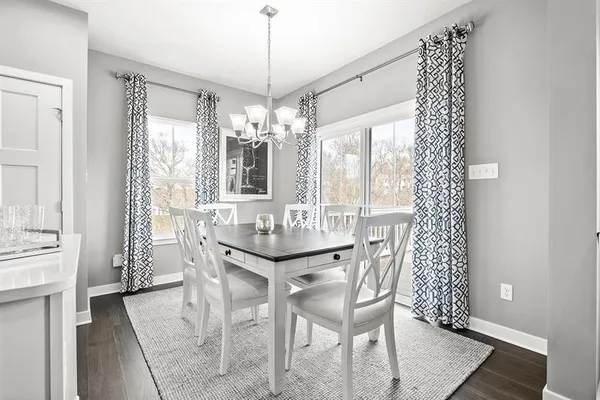 a dining room with furniture a chandelier and wooden floor