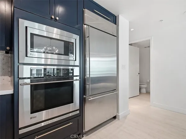 a kitchen with granite countertop stainless steel appliances and wooden floor