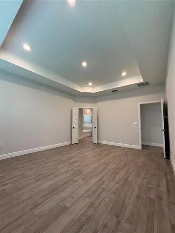 a view of empty room with wooden floor