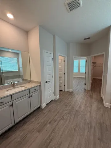 a spacious bathroom with double vanity and a mirror