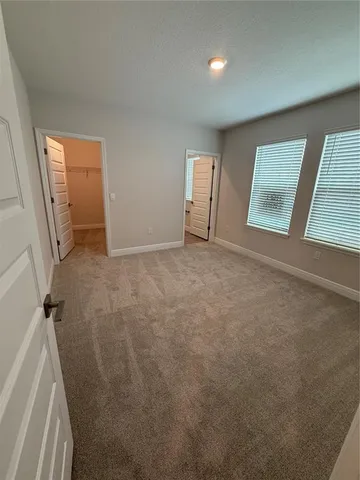 an empty room with windows and closet