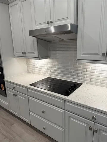 a kitchen with granite countertop white cabinets and white appliances