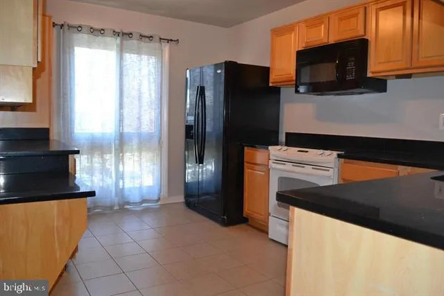 a kitchen with stainless steel appliances granite countertop a refrigerator and a stove