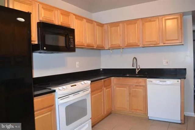 a kitchen with granite countertop white cabinets stainless steel appliances and a sink