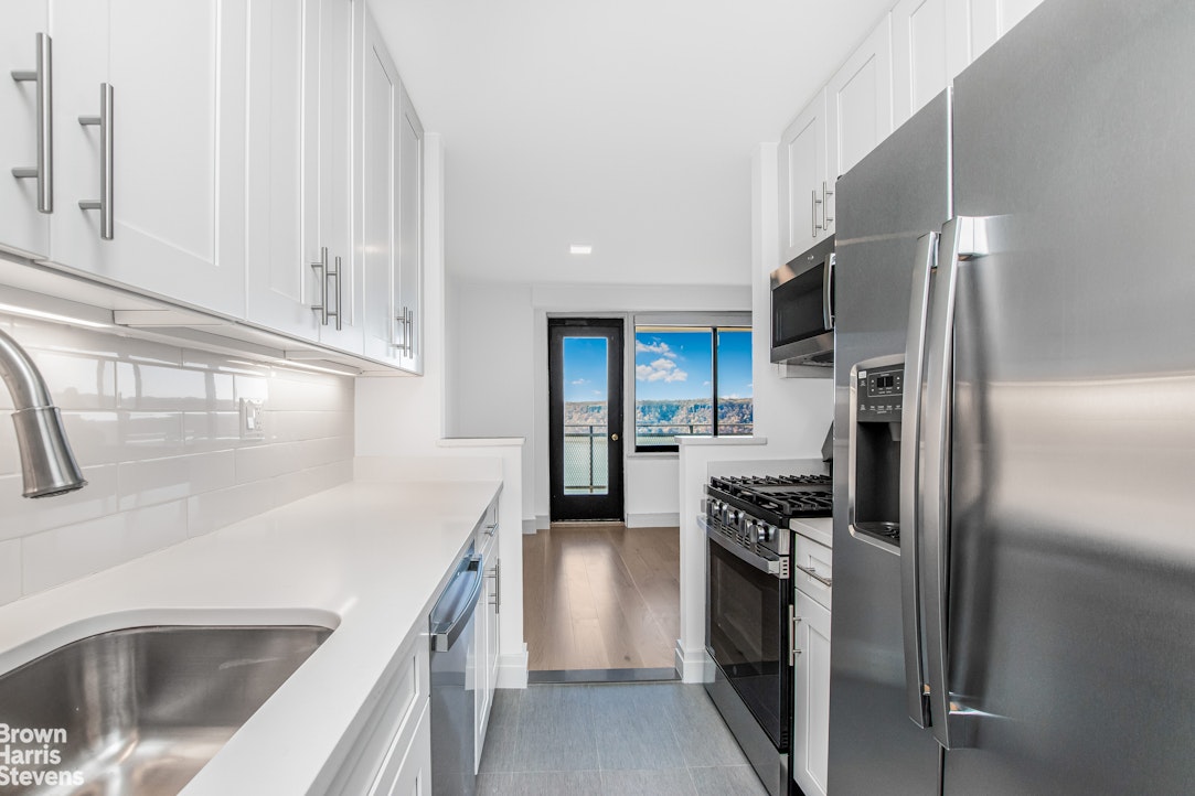 3671 Hudson Manor Terrace, Unit 14B Bronx, NY 10463 - Photo 3 of 11 a kitchen with a refrigerator sink and cabinets