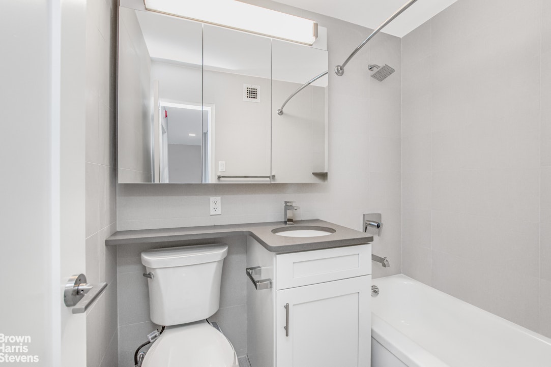 3671 Hudson Manor Terrace, Unit 14B Bronx, NY 10463 - Photo 6 of 11 a bathroom with a sink a toilet and a bathtub