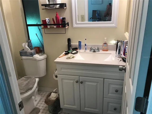 a bathroom with a sink a toilet and a mirror