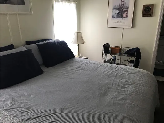 a bedroom with a bed and a lamp on table