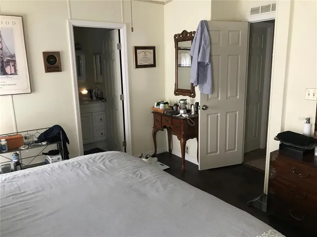 a bedroom with a bed closet and a mirror
