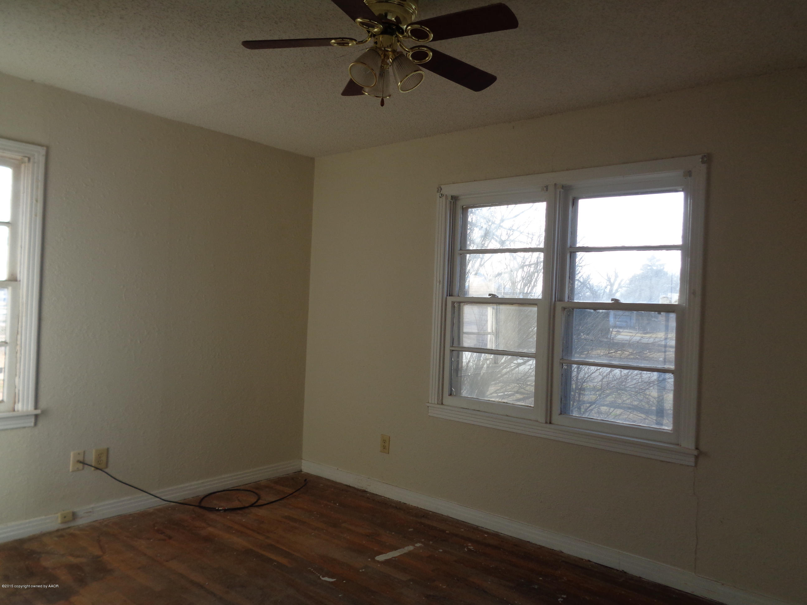 4345 South Tyler Street Amarillo, TX 79110 - Photo 7 of 10 a view of an empty room with wooden floor and a window