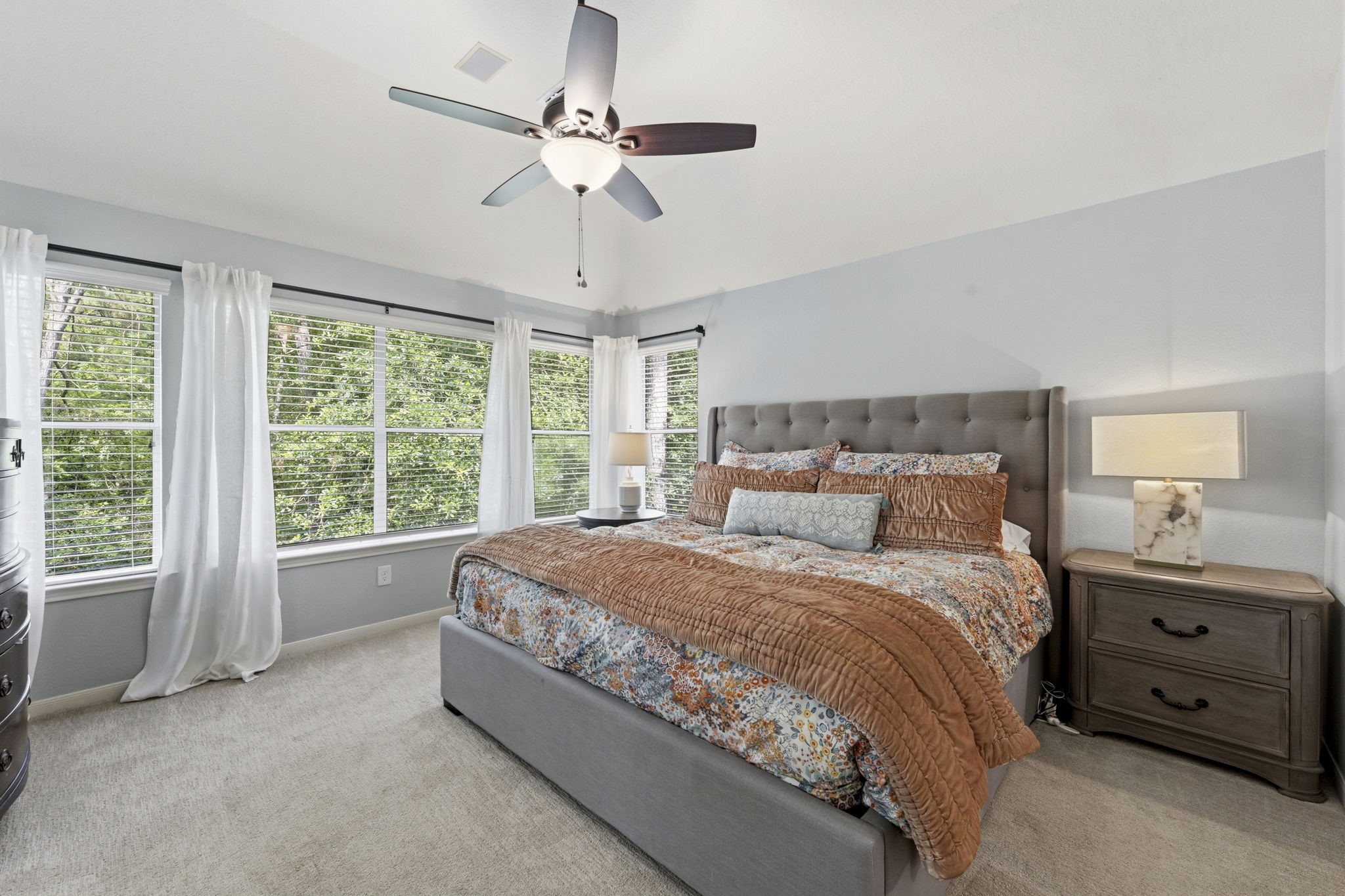 6 North Flickering Sun Circle Spring, TX 77382 - Photo 15 of 33 Oversized primary bedroom big enough for this king sized bed. Notice all the greenery outside the wall of windows!
