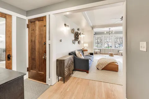 a view of a hallway with wooden floor and furniture