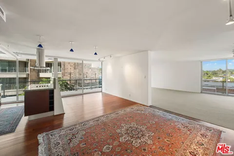 a view of a living room hardwood floor and a kitchen
