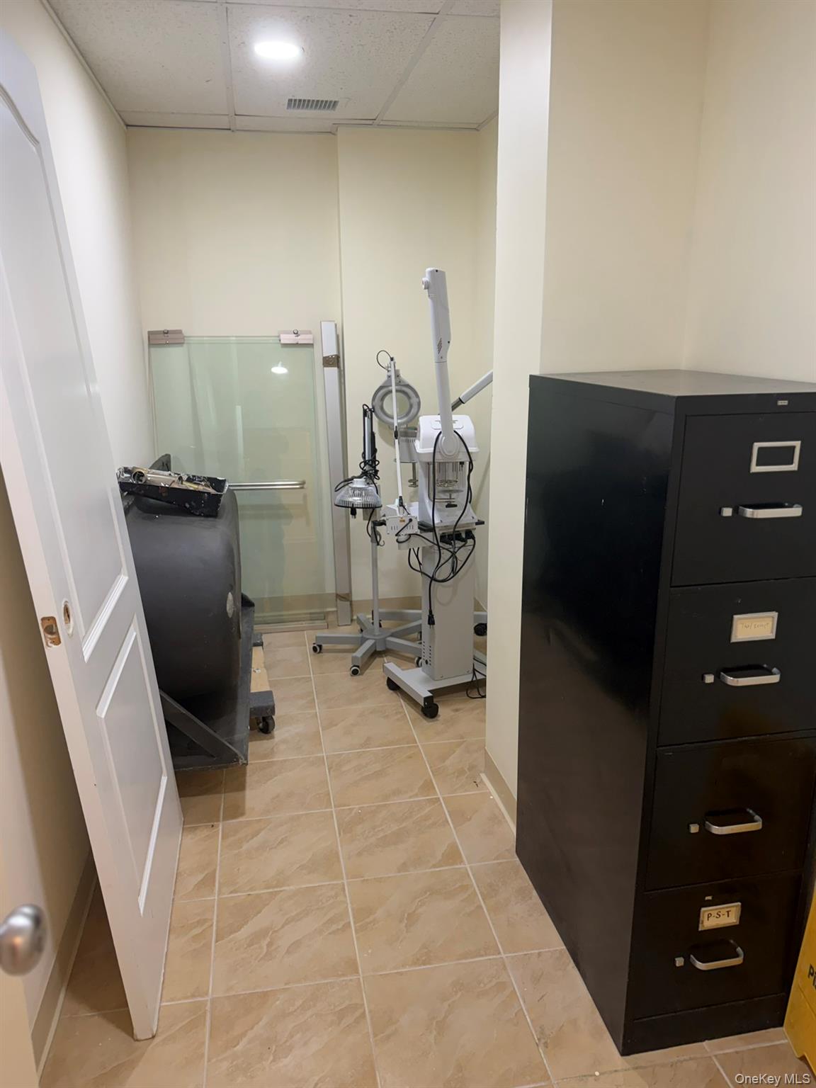 42-23 212th Street, Unit 3C Queens, NY 11361 - Photo 13 of 13 Exercise room with light tile patterned flooring and a drop ceiling