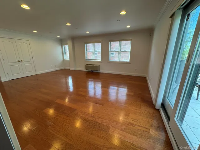 a view of empty room with wooden floor