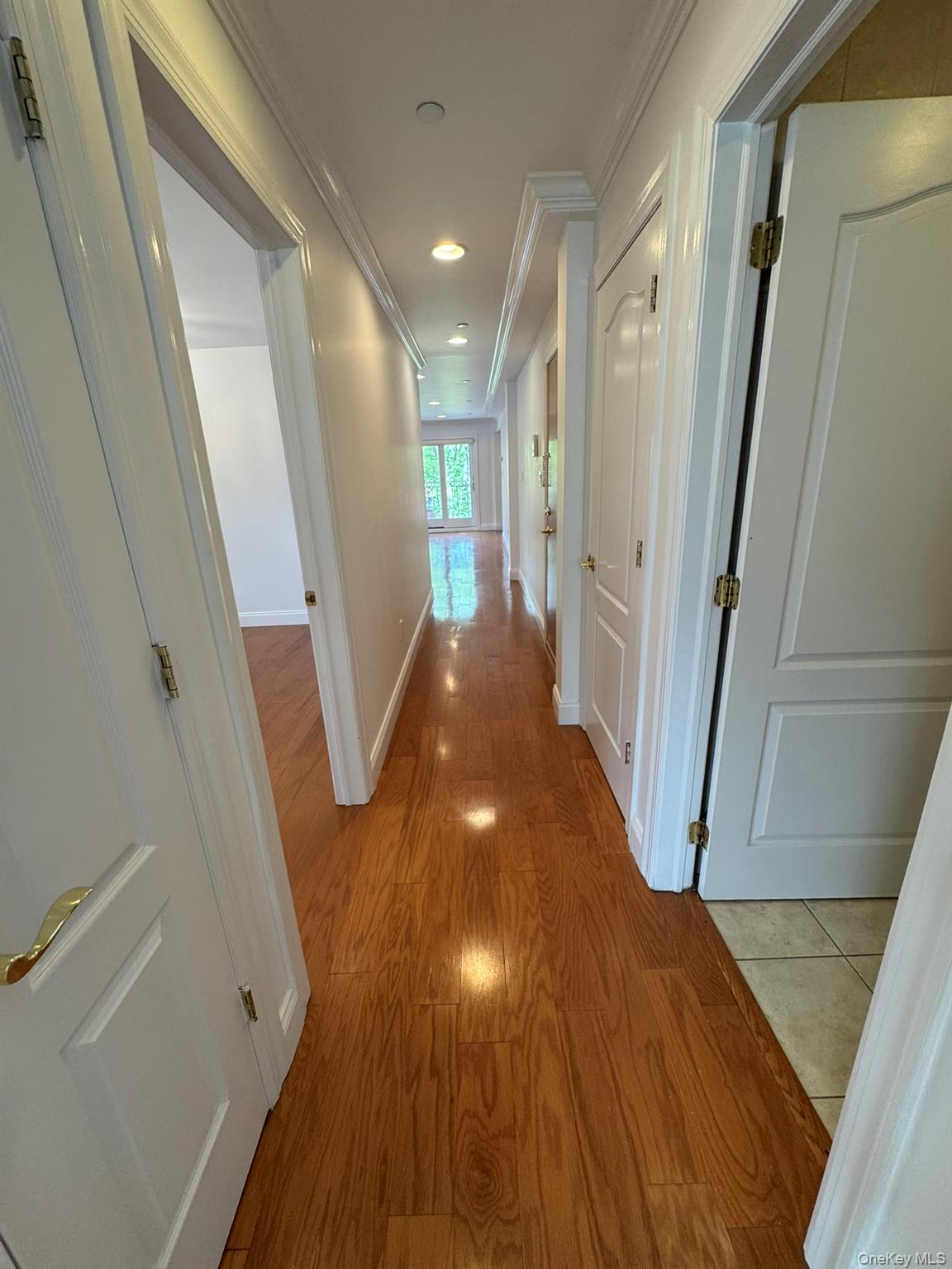 42-23 212th Street, Unit 3C Queens, NY 11361 - Photo 3 of 13 Corridor with ornamental molding, wood finished floors, recessed lighting, and baseboards
