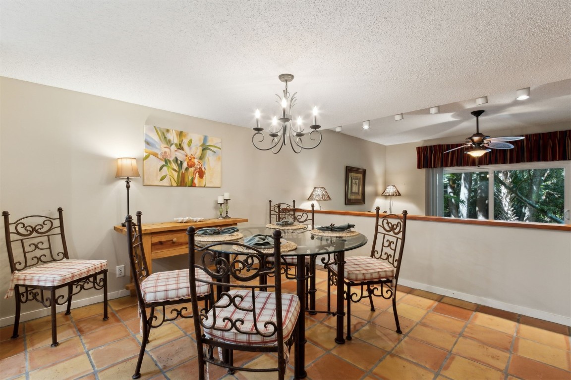 3028 Sea Marsh Road, Unit 3028 Fernandina Beach, FL 32034 - Photo 11 of 39 a view of a dining room with furniture a chandelier and wooden floor