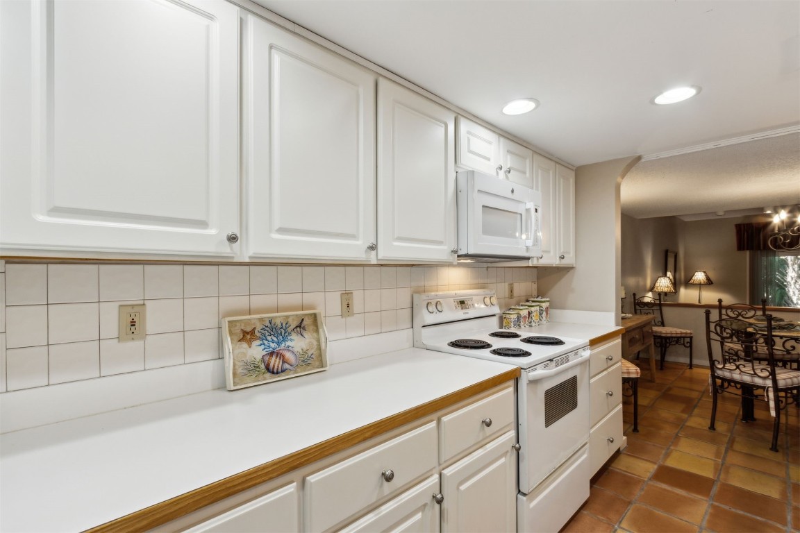 3028 Sea Marsh Road, Unit 3028 Fernandina Beach, FL 32034 - Photo 9 of 39 a kitchen with stainless steel appliances white cabinets and stove top oven